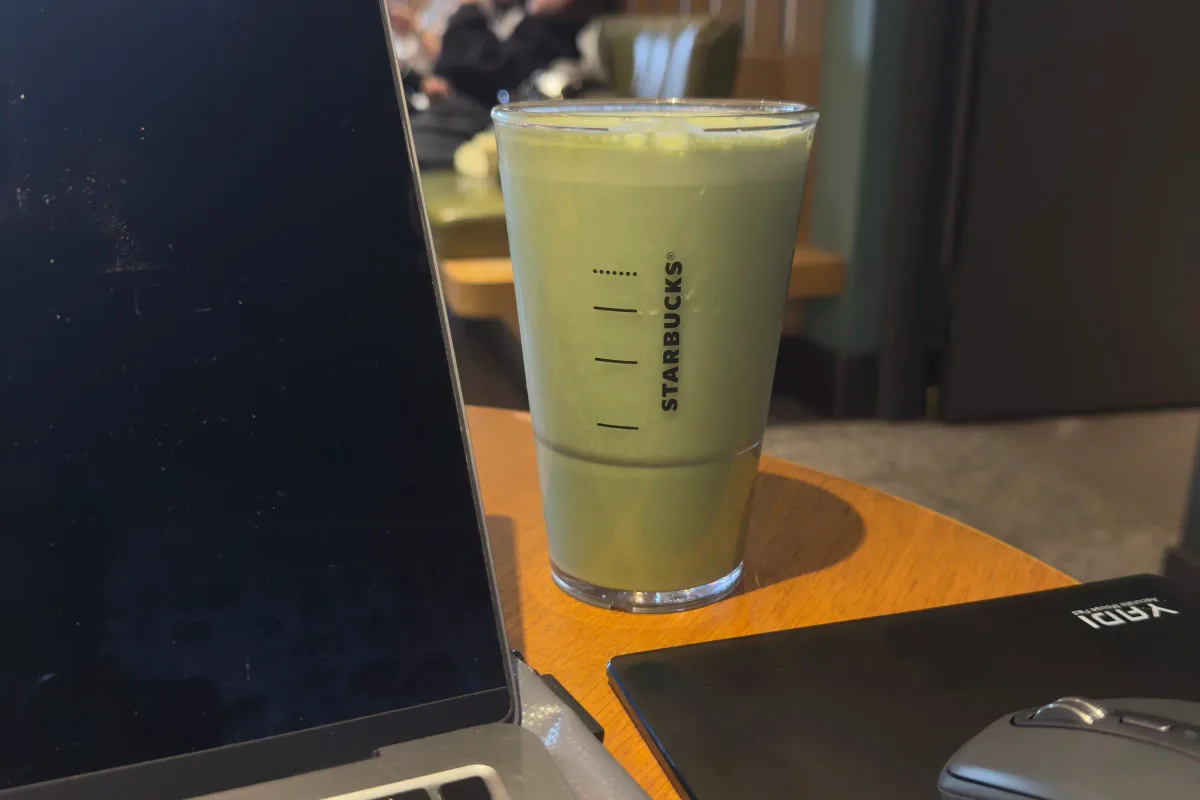 咖啡廳桌上的 MacBook、抹茶飲品與滑鼠；搭配效率上升、需求持平的概念排版